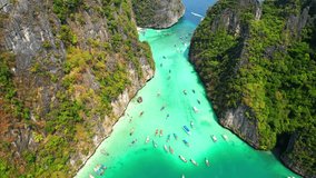 Aerial views from drones flying over tropical seas, Limestone mountains and clear blue waters, tour boats and long-tail boat. Phi Phi Islands, Krabi, most beautiful places to visit in Thailand. 4K UHD