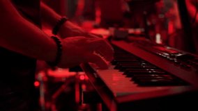 Close-up of male hands playing electric piano under colorful stage lighting. A musician in a suit performs a composition on a keyboard music workstation on a party night.
 - Powered by Shutterstock - Get 15% off with code: PIKWIZARD15