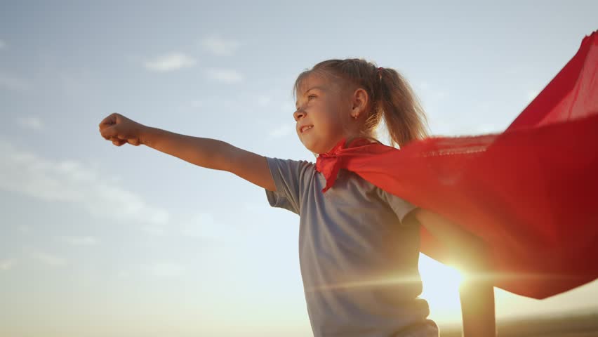 Kid superhero. girl daughter happy family a dream concept. baby girl superhero close-up in red cape at sunset. portrait child superhero close-up. lifestyle strength fantasy concept | Shutterstock HD Video #1100502715