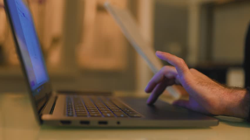 An intense close-up of a broker's hands on a laptop keyboard at home in the nighttime, as they analyze market data and make trading decisions. | Shutterstock HD Video #1100504341