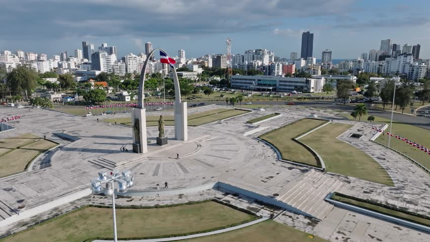 Aerial orbit shot of Plaza de la Bandera in Santo Domingo with skyline in background
