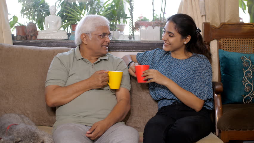 A cheerful old gentleman and his adult daughter spend quality time - in casual conversation - bonding and care. An Indian father-daughter duo are enjoying while drinking a cup of tea-coffee togethe... Royalty-Free Stock Footage #1100523447
