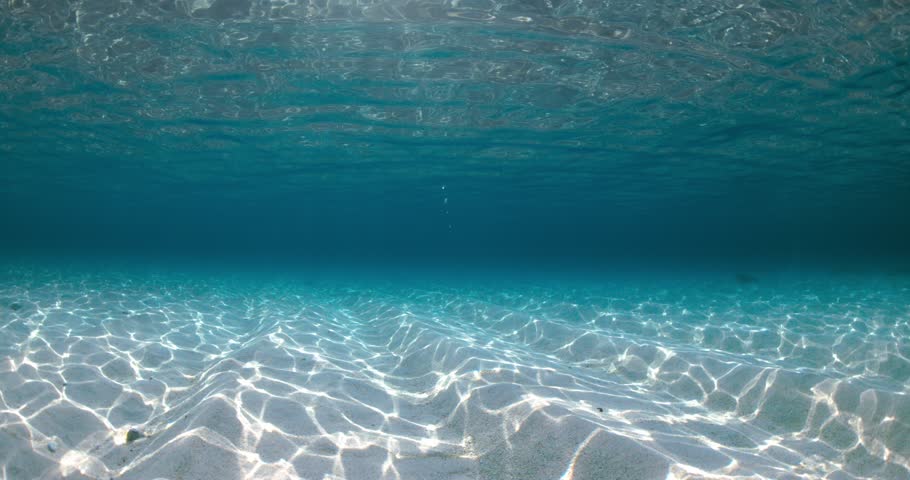Transparent ocean with waves, sandy bottom underwater in sunny day | Shutterstock HD Video #1100523497