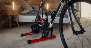 Dynamic video footage, details of a bike set up at a bike station for indoor training in a stylish bedroom, no people