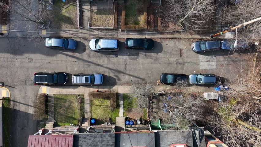 Top down aerial view of housing neighborhood in city suburb. American houses in urban outskirt with street parking. Royalty-Free Stock Footage #1100535807