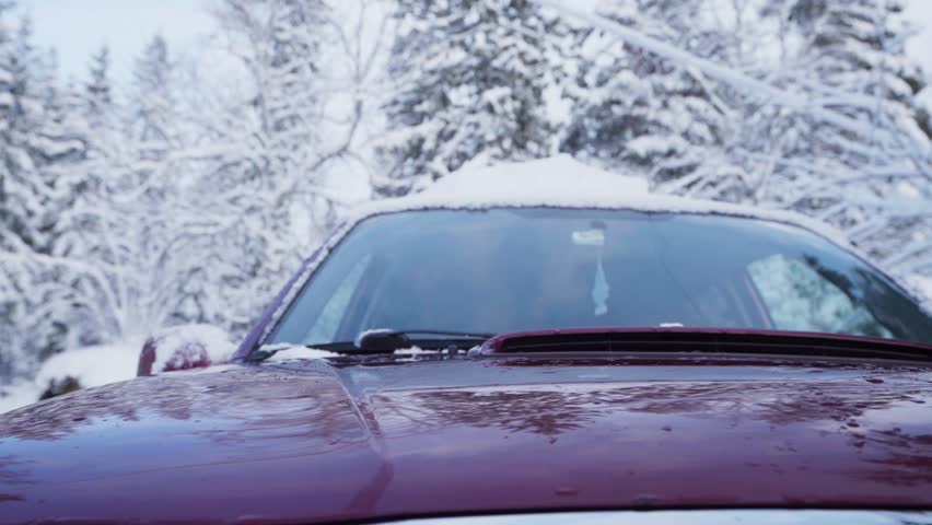 Knitted Beanie Hat And Pair Of Gloves Thrown On The Car Hood With Snow-covered Roof In Winter. static | Shutterstock HD Video #1100536093