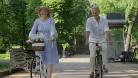 Mature couple cycling in park on their first date, positive seniors outdoor - Powered by Shutterstock - Get 15% off with code: PIKWIZARD15