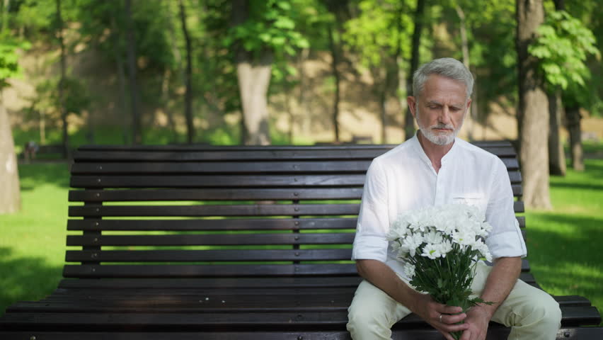 Worried man in his 60s waiting for woman in park, being stood up on a date Royalty-Free Stock Footage #1100542461