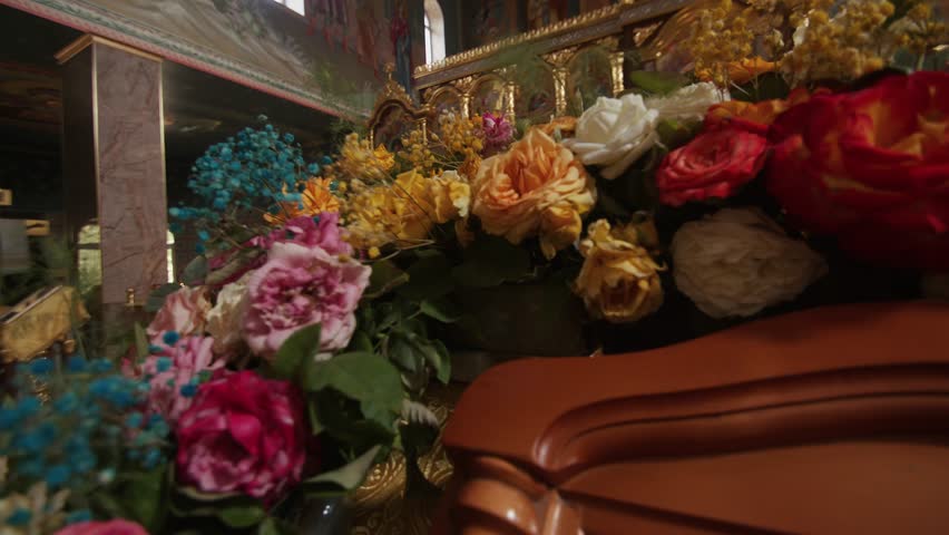 Icon with saints in a wooden frame and decorated with flowers on a lectern in the orthodox church | Shutterstock HD Video #1100544981