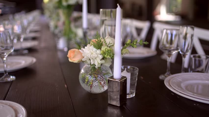 A very nicely decorated wedding table appointments with beautiful decor with plates and serviettes in spring garden. Beautiful flowers on table in wedding day. The elegant dinner table. Wedding day | Shutterstock HD Video #1100546227