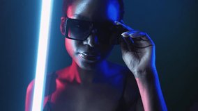 Eyewear fashion. Neon light face. Cyberpunk beauty. Blue red color mysterious girl posing in stylish sunglasses in smoke cloud at dark night with white LED lamp illumination. - Powered by Shutterstock - Get 15% off with code: PIKWIZARD15