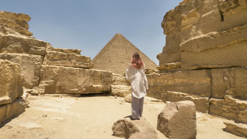 Egypt - circa 2022 - rear view of a woman taking pictures of the pyramids of giza. Royalty-Free Stock Footage #1100550027