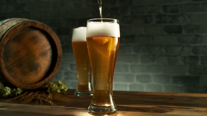 Super slow motion of pouring beer into pint in motion. Filmed on high speed cinema camera, 1000 fps. Camera placed on high speed cine bot. Speed ramp effect. Royalty-Free Stock Footage #1100551591