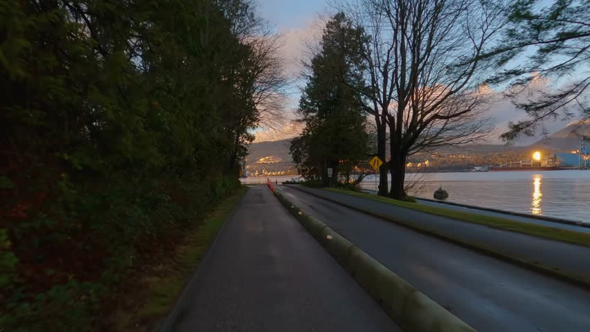 Driving in Stanley Park during winter Sunset. Downtown Vancouver, British Columbia, Canada. Adventure Travel. Slow Motion Cinematic