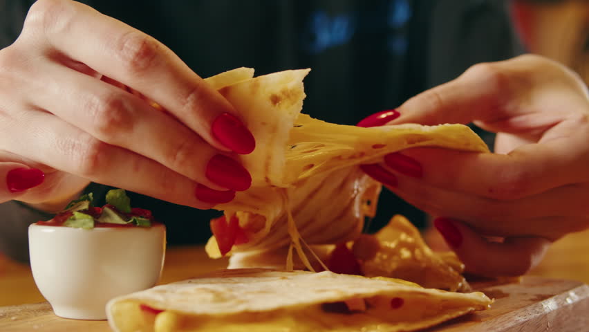 Close up of cheese quesadilla, Eating Traditional Mexican food, tex mex cuisine. Hands taking tex mex American cooked quesadilla with vegan pork beef meat and vegetables,  Royalty-Free Stock Footage #1100558389