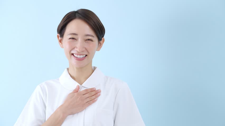 Smiling Asian nurse on blue background | Shutterstock HD Video #1100561175