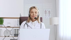 Telemedicine. Headshot portrait of smiling female doctor in headphones looking at camera. A female medical doctor remotely consults in a virtual online meeting with a patient. Online medicine