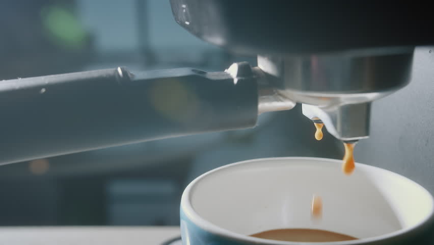 Pouring coffee stream from machine in blue cup. Home making hot Espresso in mug. Using filter holder. Flowing fresh ground coffee. Drinking roasted black coffee in the morning. 4K | Shutterstock HD Video #1100565285