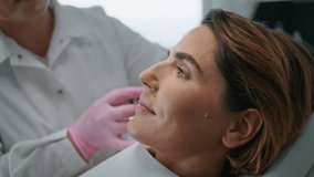 Woman making botulinum therapy in modern cosmetology clinic close up. Professional cosmetologist doing injection with botox for rejuvenation face skin. Attractive lady patient smoothing wrinkles. - Powered by Shutterstock - Get 15% off with code: PIKWIZARD15