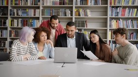 African American confident handsome positive male professor, wearing eyeglasses and formal suit, sitting at desk and giving consultation to university graduate students, using laptop in library campus - Powered by Shutterstock - Get 15% off with code: PIKWIZARD15