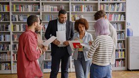 African American mid adult professor giving a lecture and explaining lesson to the diverse teenage students at the University library. People. Education. Working process in a high school institution - Powered by Shutterstock - Get 15% off with code: PIKWIZARD15