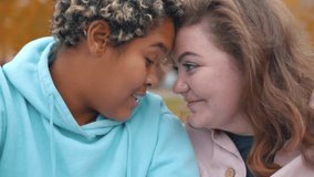 Smiling cute two ladies lgbt lesbian couple cuddle closeup. Multiethnic gay couple spending romantic time together in front of the camera. Portrait of diverse lesbian couple in love. Realtime - Powered by Shutterstock - Get 15% off with code: PIKWIZARD15