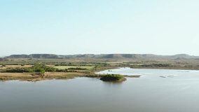 4K aerial shot of beautiful lake, farms and hills at Dhosa village of Kutch, Gujarat, India. Nature landscape aerial view. Aerial view of agriculture field in Indian village.