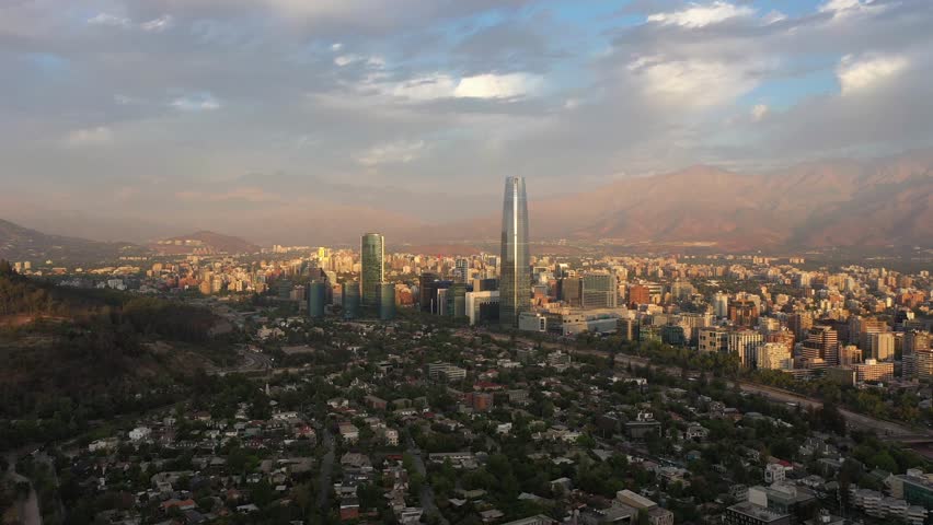 Santiago City at Sunset and Andes Mountains. Aerial View. Chile. Drone Flies Backwards and Upwards