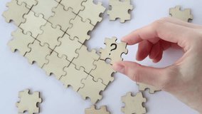 Woman's hand holds a wooden puzzle with a question mark against a background of empty puzzles. The concept of problem solving. - Powered by Shutterstock - Get 15% off with code: PIKWIZARD15