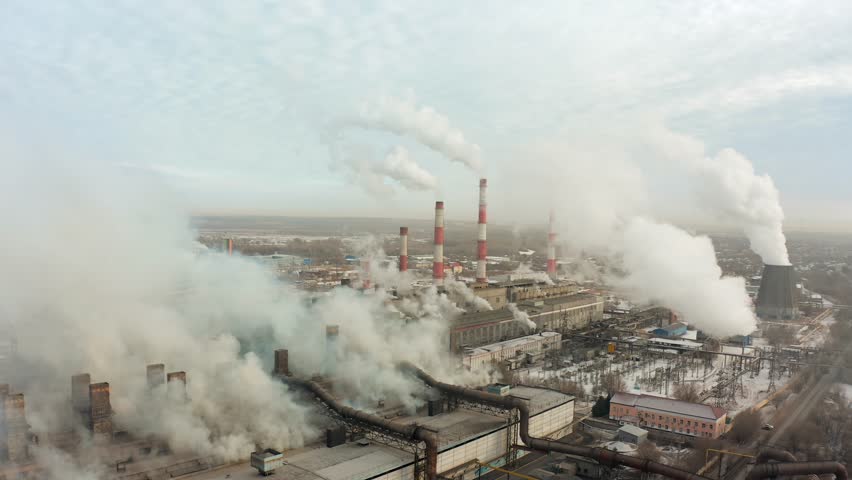 Flying a drone around a thermal power plant with smoking chimneys against the backdrop of a city covered in smog and a plain covered with snow. B-roll 4k
 Royalty-Free Stock Footage #1100580765