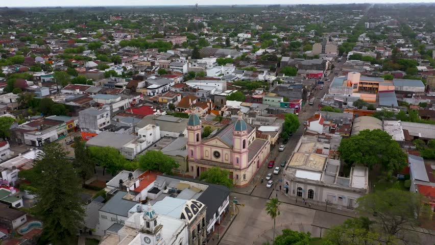 Sinking aerial of small town and flat green landscape in Argentina