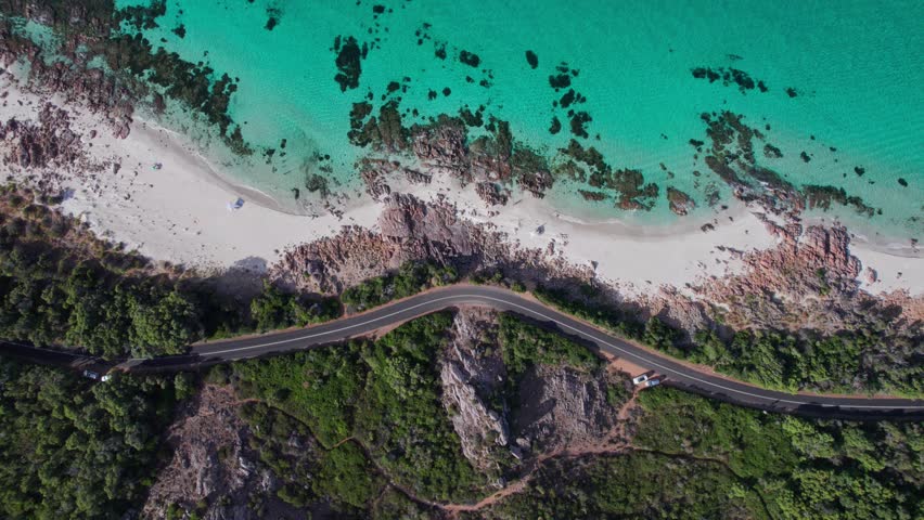 Aerial topdown anticlockwise rotation while flying up of the coastline road and ocean in Eagle Bay Western Australia