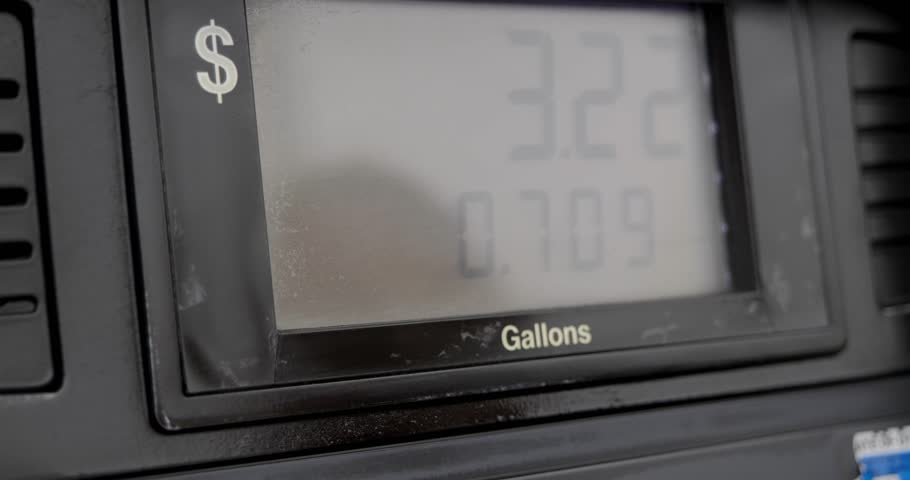 Gas station pump screen filling up and pumping slowly to 5 dollars and a little over a gallon with out of focus reflection of person in screen. | Shutterstock HD Video #1100587381
