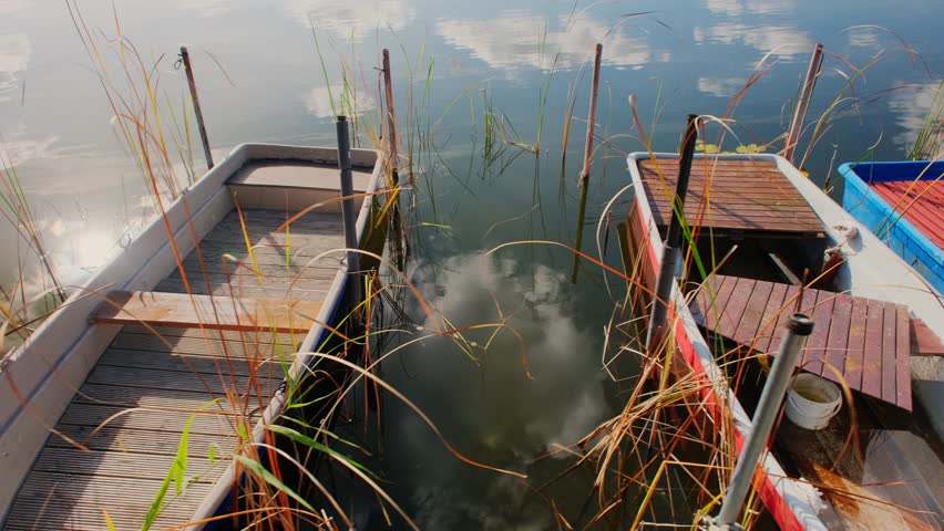 Small fishing boats anchored on the shore of the lake. Fishing harbor.