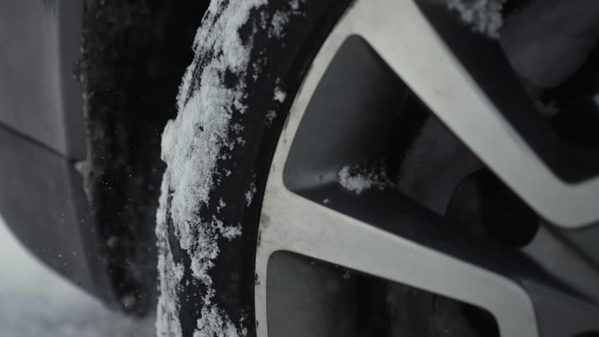Rotating wheels of car, spinning tire by untreated from snow country road with deep snowdrifts in winter. SUV vehicle struggling to gain traction on winter road spews up snowy pieces | Shutterstock HD Video #1100588961