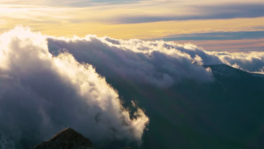 Foehn Clouds motion downhill over mountains ridge in sunny spring evening | Shutterstock HD Video #1100589389