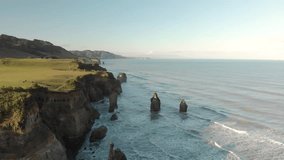 Amazing drone video shot of eroded rock formations by the sea with the view of snowcapped mountain behind. New Plymouth, Taranaki Region, New Zealand