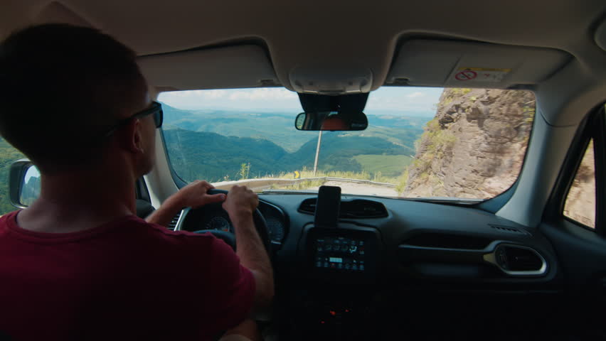 Driver steers the car on an extremely bumpy and narrow road in highlands