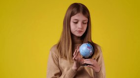 4k video of one girl looking at small globe.