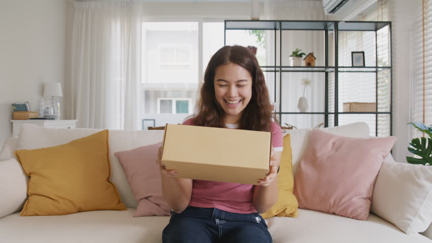 Asia people young woman smile love hug parcel box goods carton packaging happy joy awe face at home. Omni channel enjoy buy gift order postal at retail online shop store fast courier sending service. | Shutterstock HD Video #1100602297