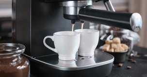 Home Espresso making process - coffee stream pouring from machine into ceramic cup