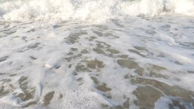 Powerful waves and foamy water crushing stones and pebbles on beach 