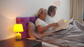 Senior couple read books in bed. Mature husband and wife reading literature in bedroom. Aged man and woman enjoy novel before sleep. Retirement, marriage concept. Realtime  - Powered by Shutterstock - Get 15% off with code: PIKWIZARD15