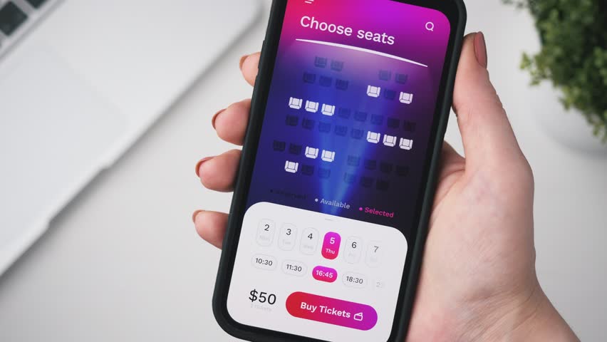 Woman buying cinema tickets online. Choosing seats in a cinema hall and buying ticketsusing app for mobile phone. Royalty-Free Stock Footage #1100612717
