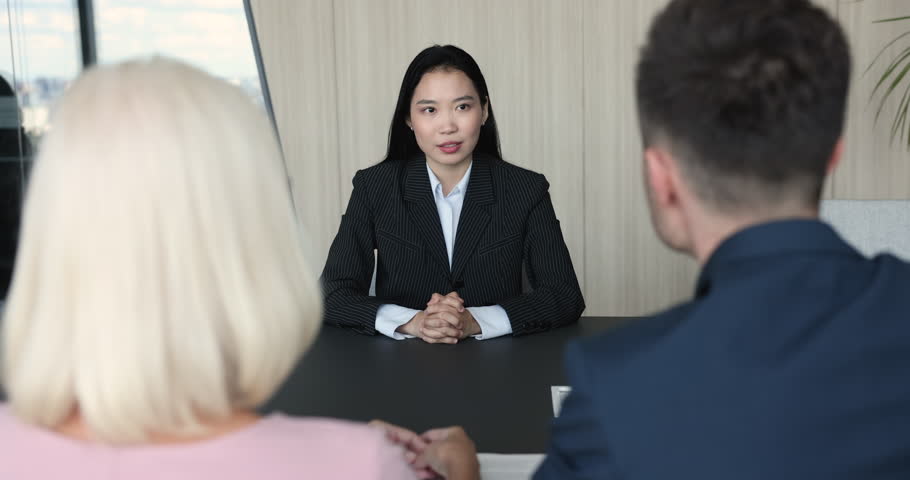 Millennial confident Asian female applicant answers questions, passes job interview successfully, shaking hands HR managers, finish formal meeting in company office. Hiring, human resources, staffing Royalty-Free Stock Footage #1100614319