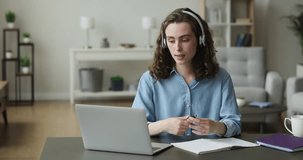 Pretty young 20s student woman in headphones talk to on-line tutor via video call app, share thoughts and ideas to mate working together on project, prepare for exams use modern wireless technologies