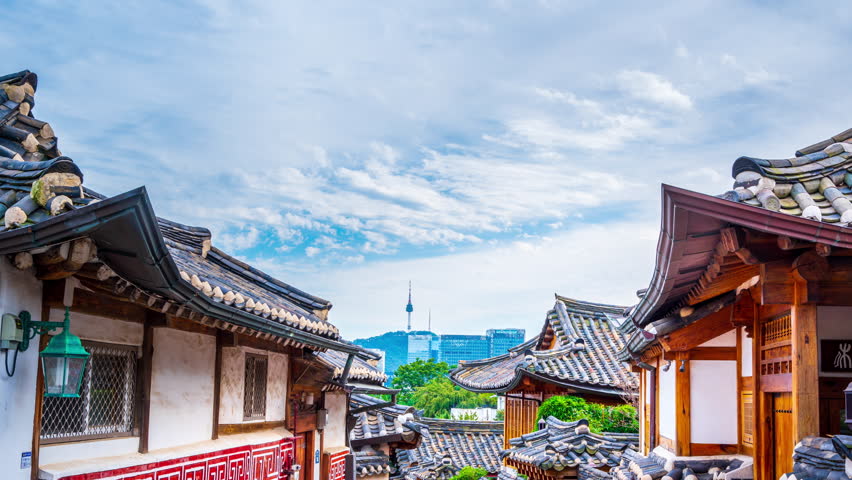 Timelapse of Bukchon Hanok Village.And there are clouds moving alternating with the blue sky,Seoul,South Korea.And there is a welcome message in traditional Korean on the sign. Royalty-Free Stock Footage #1100614615