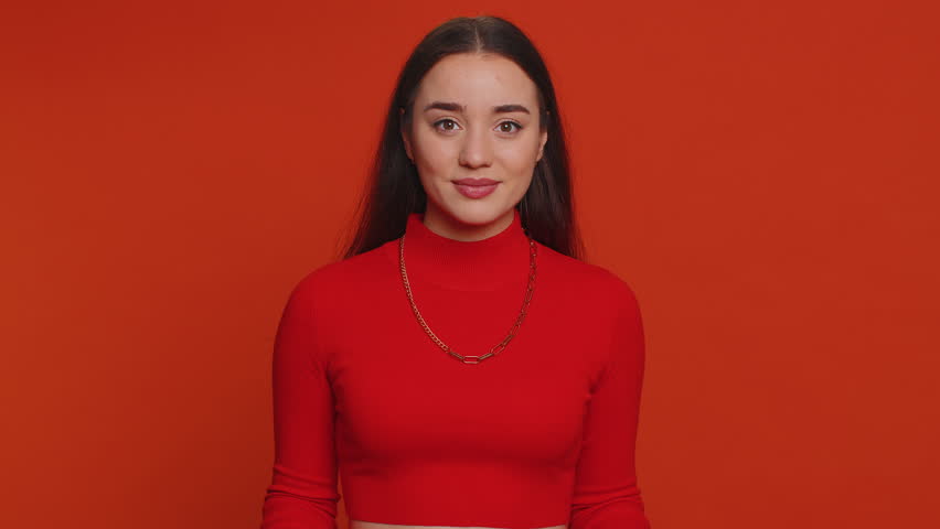 Young woman in crop top showing shopping bags, advertising discounts, smiling looking amazed with low prices, shopping on Black Friday holidays. Girl indoors isolated alone on studio red background Royalty-Free Stock Footage #1100615041