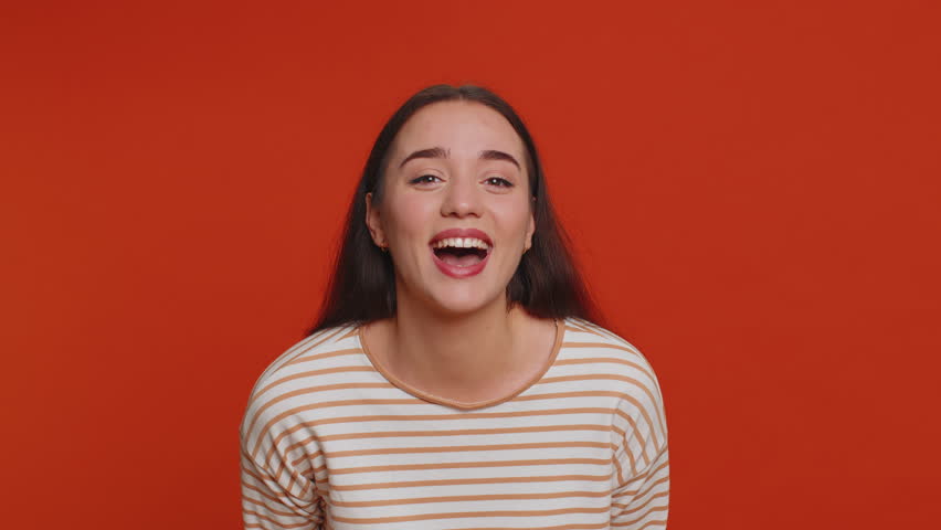 Amused pretty woman pointing finger to camera, laughing out loud, taunting making fun of ridiculous appearance, funny joke anecdote, bullying. Young adult girl isolated alone on red studio background Royalty-Free Stock Footage #1100615069