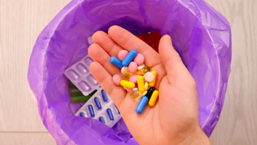 throws medicine pills into the trash.